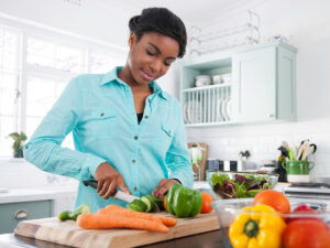 Woman Cutting Vegetables in Kitchen