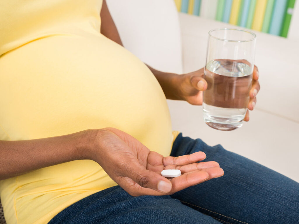 Pregnant woman taking vitamin.